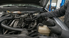 Mechanic inspecting the CCV oil separator on a 6.7 Powerstroke diesel engine