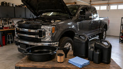 Ford Super Duty diesel truck with oil change supplies in a garage